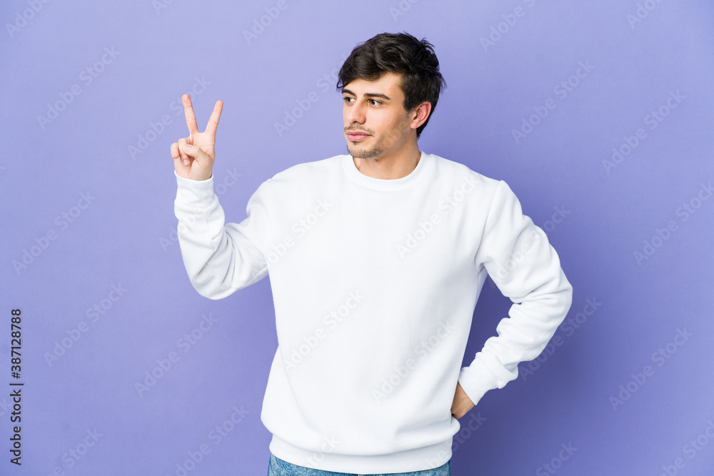 Young cool man joyful and carefree showing a peace symbol with fingers. Young cool man joyful and carefree showing a peace symbol with fingers.