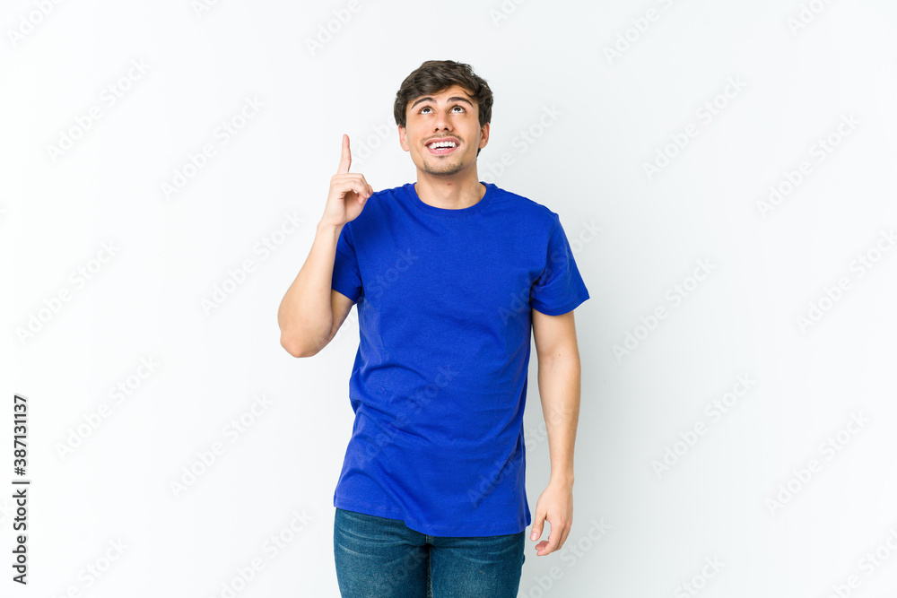 Young cool man indicates with both fore fingers up showing a blank space. Young cool man indicates with both fore fingers up showing a blank space.