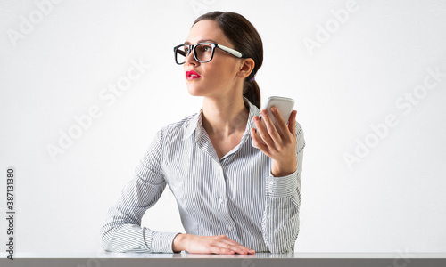 Smiling young woman sits at desk