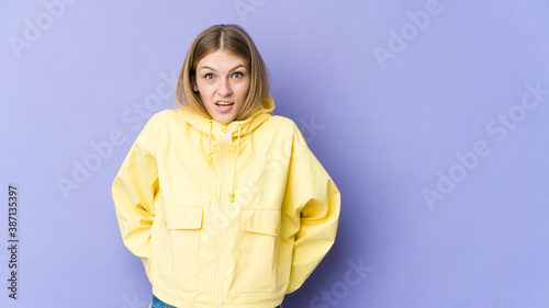 Young blonde woman isolated on purple background being shocked because of something she has seen. © Asier