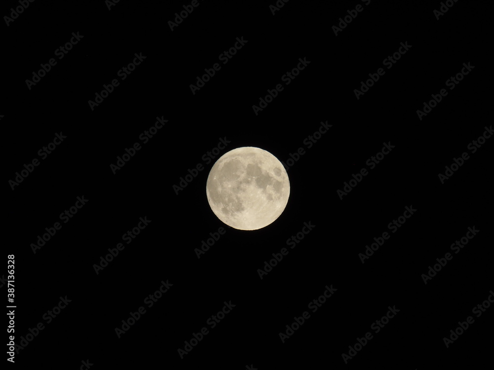 Obraz premium Genova, Italy - 09/25/2020: An amazing photography of the full moon over the city of Genova by night with a great clear sky in background and some stars