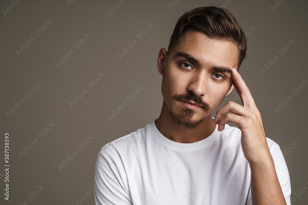 Image of caucasian unshaven guy posing on camera with arms crossed Image of caucasian unshaven guy posing on camera with arms crossed