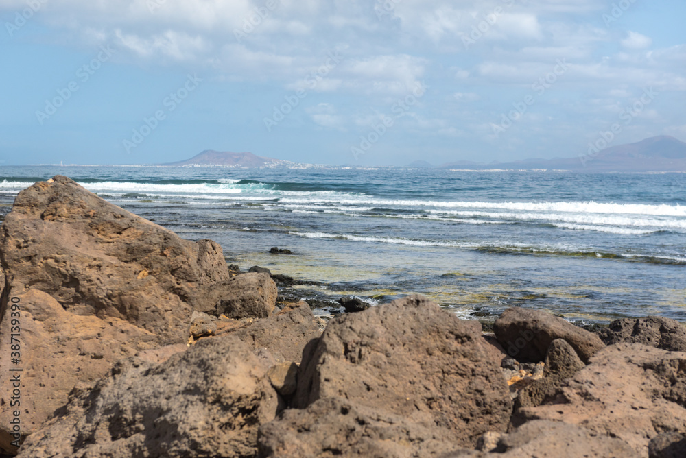 Sunny day on the coast of Fuerteventura where you can see Lanzarote in the distance in the Canary Islands in Spain