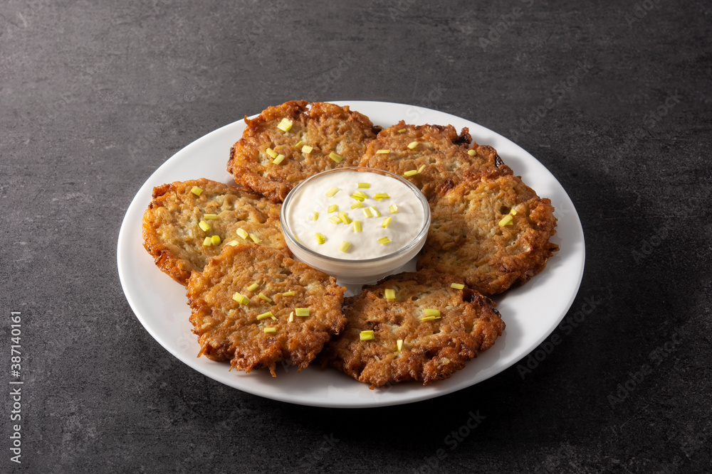 Traditional Jewish latkes or potato pancakes on black stone