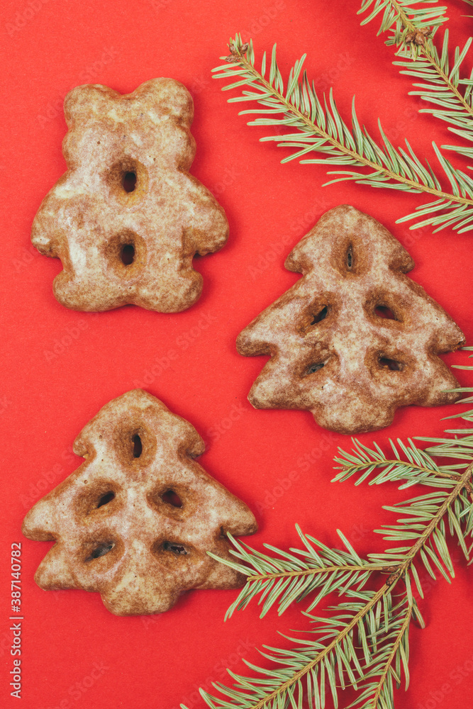 Ginger cookies and fir tree branch on a red background. Ginger cookies and fir tree branch on a red background.