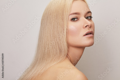Beautiful woman with straight blond hair. Model with natural style make-up, clean skin. Shiny long health hairstyle