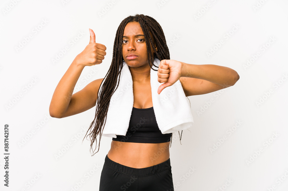 Young african american sport woman isolated showing thumbs up and thumbs down, difficult choose concept Young african american sport woman isolated showing thumbs up and thumbs down, difficult choose concept