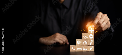 Fotografie Hand arranging wood block with healthcare medical icon