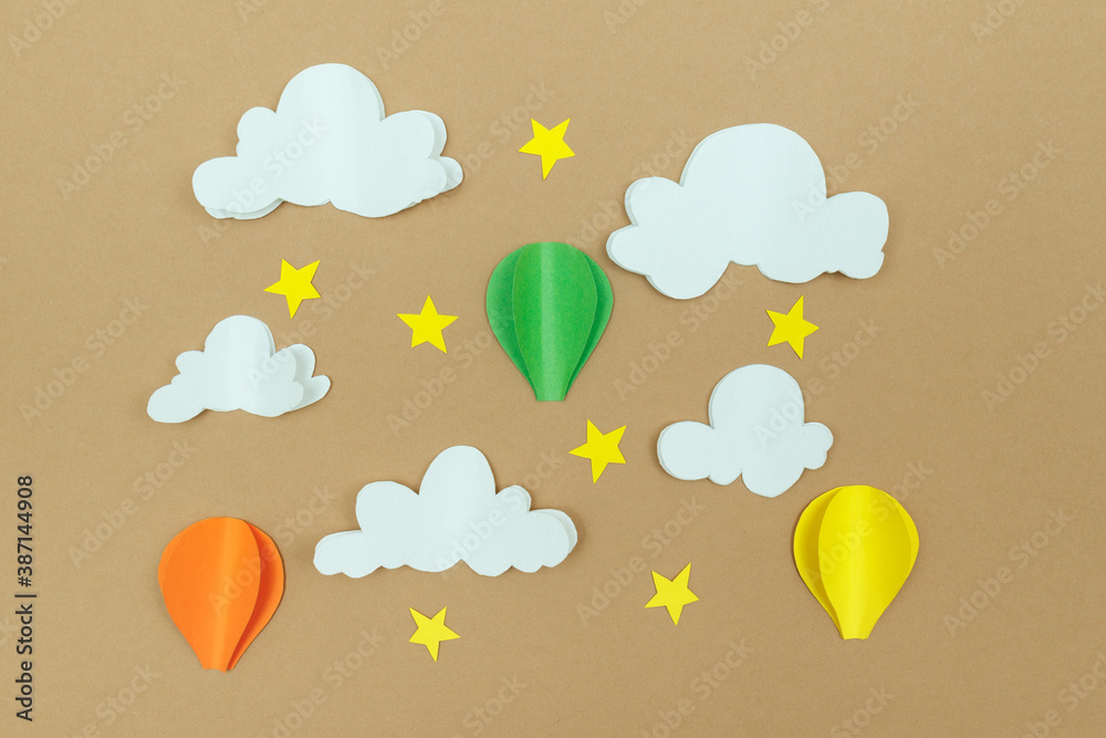 Cardboard clouds, stars and air balloons on the beige background. Balloons in the sky with stars and clouds.
