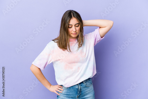 Young caucasian woman having a neck pain due to stress, massaging and touching it with hand.