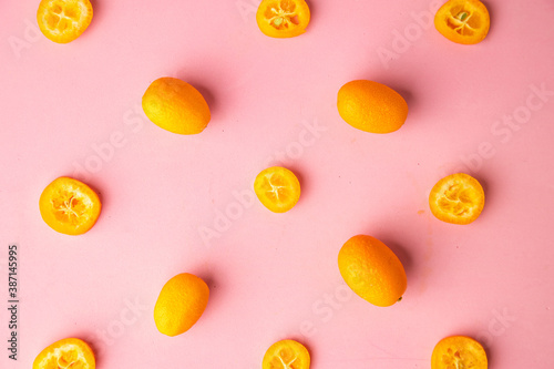 kumquat orange fruit on pink background