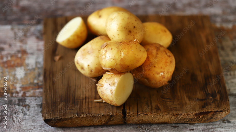 Fresh raw potatoes on a wooden surface. Fresh raw potatoes on a wooden surface.