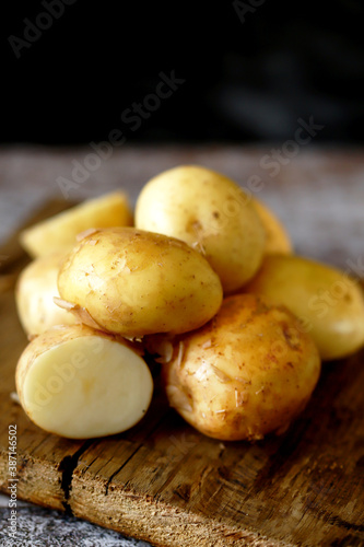 Fresh raw potatoes on a wooden surface.