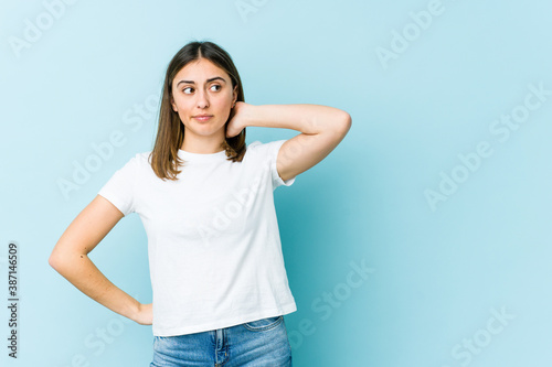 Young caucasian woman touching back of head, thinking and making a choice.