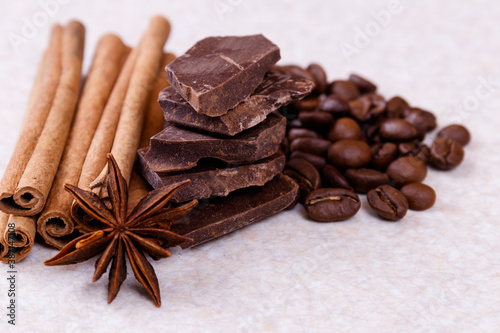 Wallpaper Mural Stack of chocolate bar pieces with heap of roasted coffee beans and spices, cinnamon sticks and anise stars on a white table. Macro shot. Torontodigital.ca