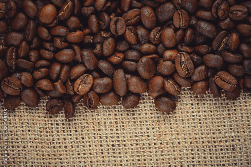 Roasted coffee beans on burlap. Background for coffee shops and store websites Roasted coffee beans on burlap. Background for coffee shops and store websites