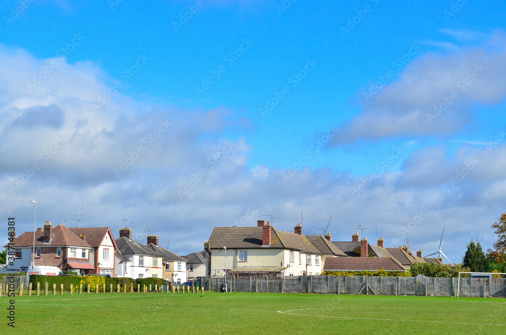 Two-story houses near a football field on a sunny day. Two-story houses near a football field on a sunny day.