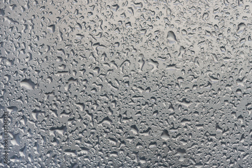 water drops on glass background texture. rain on the grey window