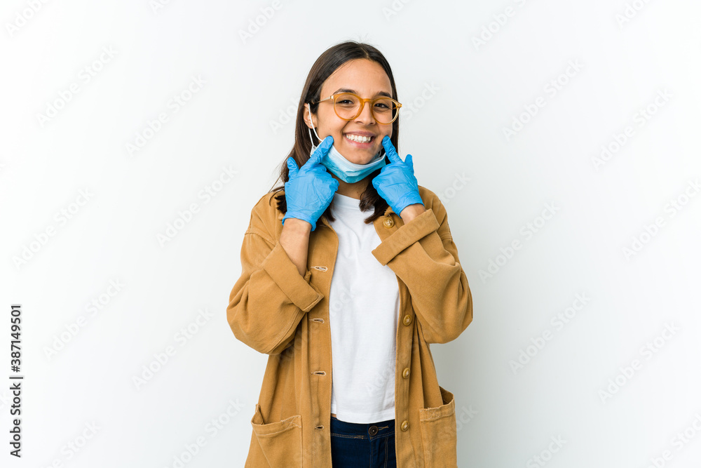 Young latin woman wearing a mask to protect from covid isolated on white background doubting between two options. Young latin woman wearing a mask to protect from covid isolated on white background doubting between two options.