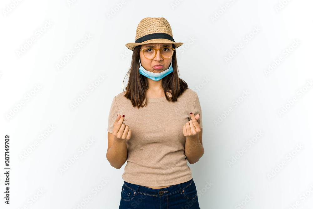 Young latin woman wearing hat and mask to protect from covid isolated on white background showing that she has no money. Young latin woman wearing hat and mask to protect from covid isolated on white background showing that she has no money.