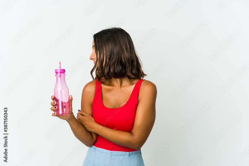 Young latin woman holding a milkshake isolated on white background Young latin woman holding a milkshake isolated on white background