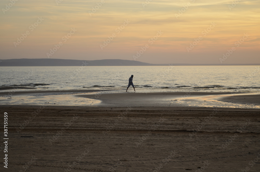 silhouette of a person walking on the beach