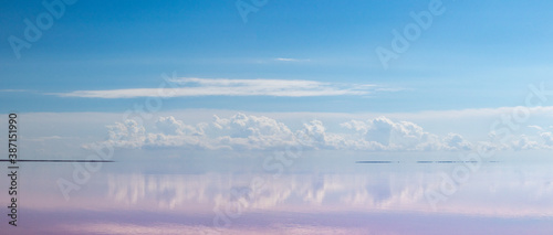 Pink salt lake water with clouds and blue sky