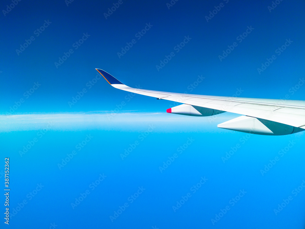 wing of an airplane during flight in a clear blue sky with copy space. wing of an airplane during flight in a clear blue sky with copy space.