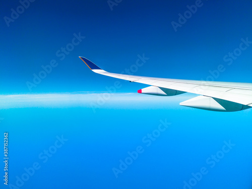 wing of an airplane during flight in a clear blue sky with copy space.