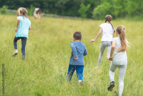 Group of kids running around on a field and having fun together