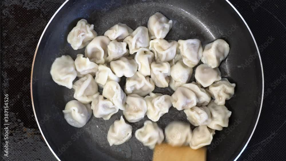 Boiled dumplings are fried in a hot pan. Boiled dumplings are fried in a hot pan.