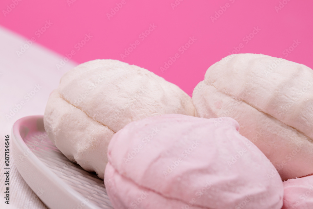 Tasty sweet zephyr on a plate and pastel pink background. Unusual horizon line. Tasty sweet zephyr on a plate and pastel pink background. Unusual horizon line.