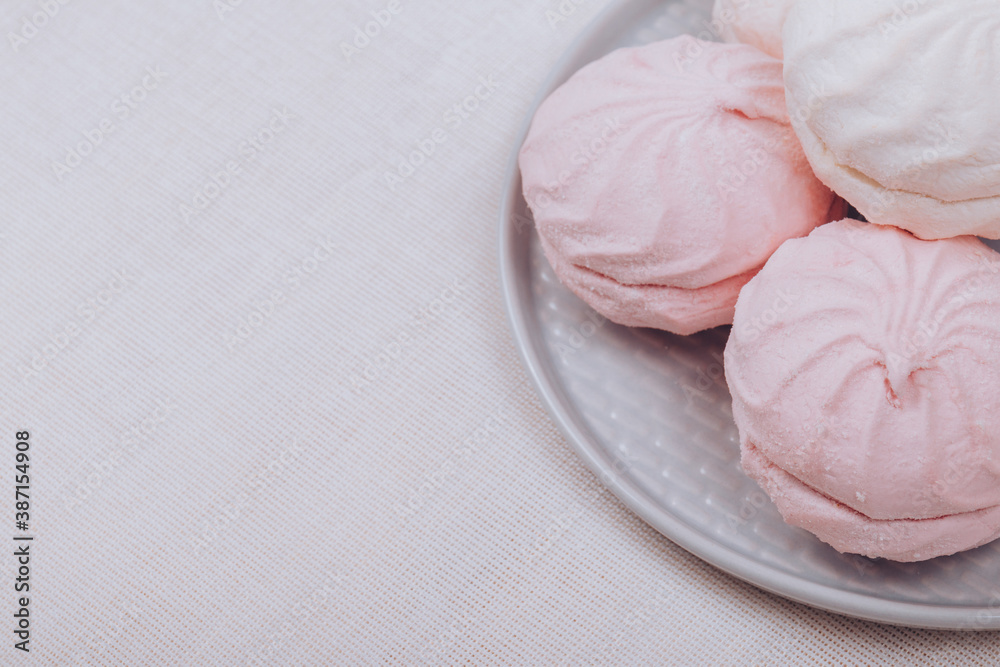 Tasty sweet zephyr on a plate and tablecloth background. Tasty sweet zephyr on a plate and tablecloth background.