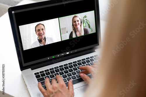 Back view of business woman talking to her colleagues about plan in video conference. Multiethnic business team using laptop for a online meeting in video call. Group of people smart working from home