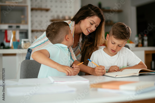 Mother helping her son with homework at home. Little boy learning at home.