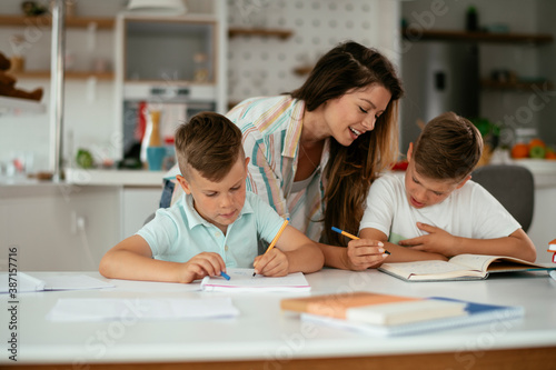 Mother helping her son with homework at home. Little boy learning at home.