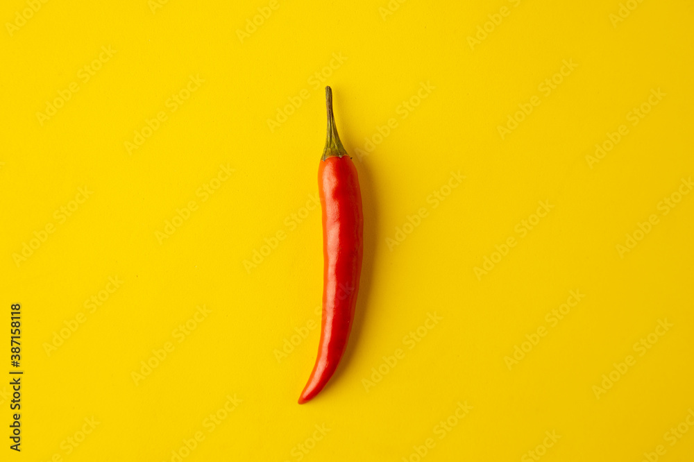 spicy red chili pepper on yellow background