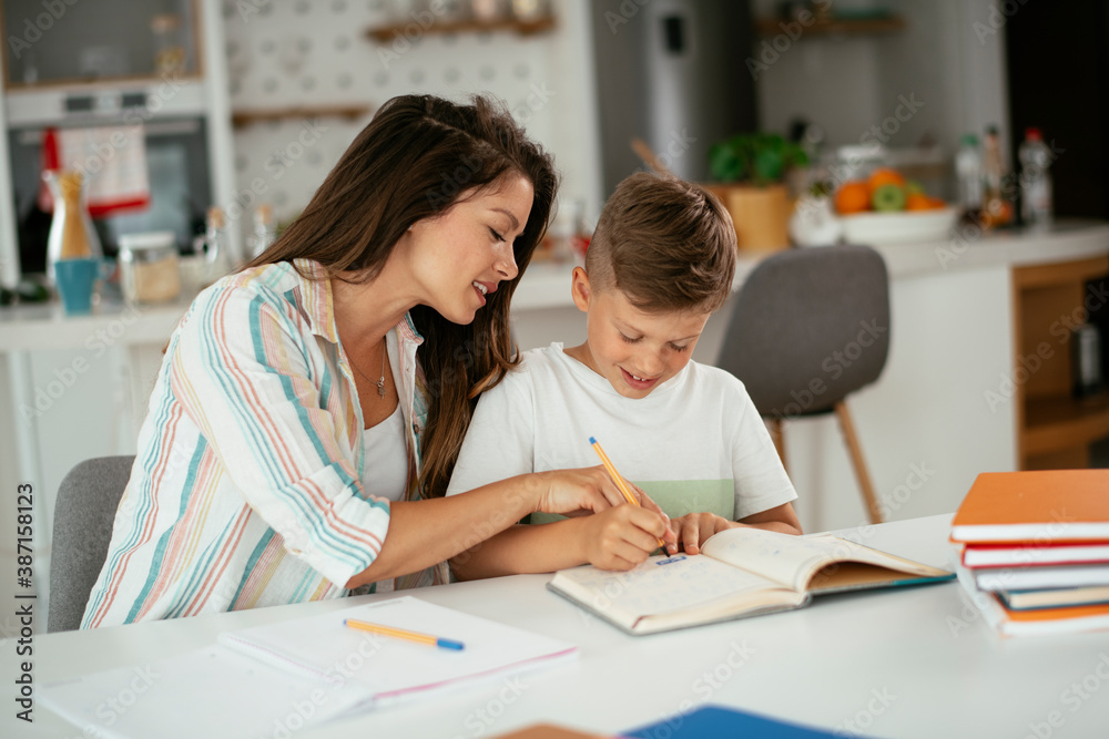 Mother helping her son with homework at home. Little boy learning at home. Mother helping her son with homework at home. Little boy learning at home.