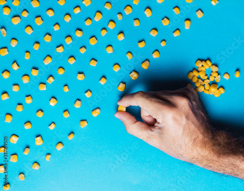Fotografie Man with obsessive compulsive disorder placing corn kernels neatly in a row