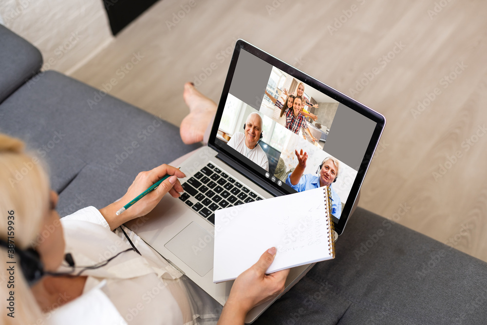 Back view of business woman talking to her colleagues about plan in video conference. Multiethnic business team using laptop for a online meeting in video call. Group of people smart working from home Back view of business woman talking to her colleagues about plan in video conference. Multiethnic business team using laptop for a online meeting in video call. Group of people smart working from home