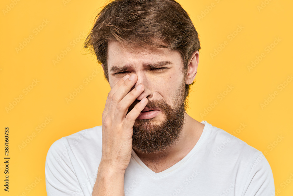 Bearded man emotions gestures with hands facial expression white t-shirt yellow background Bearded man emotions gestures with hands facial expression white t-shirt yellow background