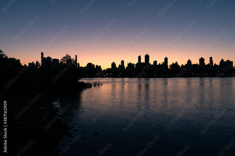 Silhouettes of Skyscrapers in the Upper East Side and Manhattan Skyline along the East River in New York City after a Sunset