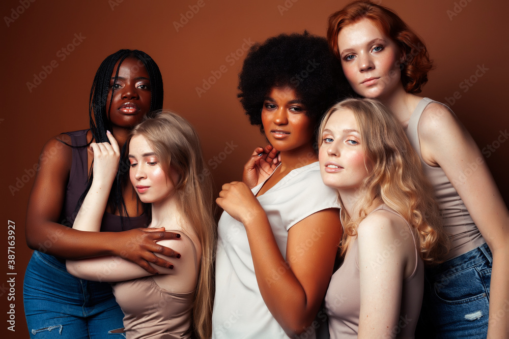Fototapeta premium young pretty caucasian, afro, scandinavian woman posing cheerful together on brown background, lifestyle diverse nationality people concept