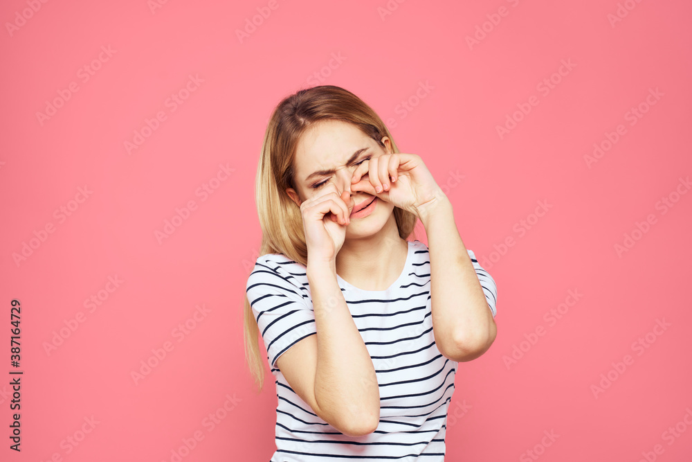 Woman in striped t-shirt emotions studio cropped view lifestyle pink isolated background Woman in striped t-shirt emotions studio cropped view lifestyle pink isolated background