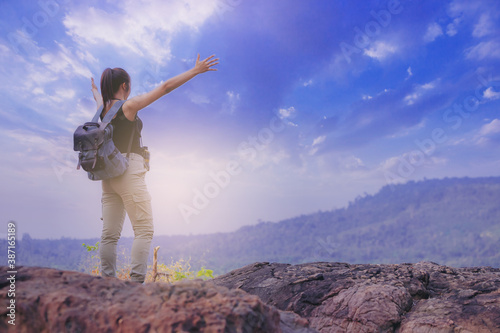 Successful female hiker at mountain peak celebrate her freedom 