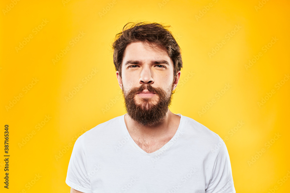 emotional bearded man in t-shirt cropped view yellow background studio emotional bearded man in t-shirt cropped view yellow background studio