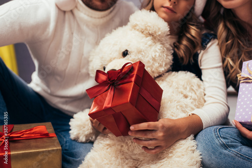 cropped view of kid holding christmas presents near parents