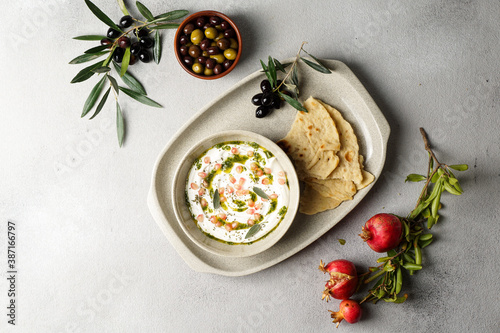 iranian or arabian dish, yogurt labneh goats milk dip with taftan bread and pomegranate photo