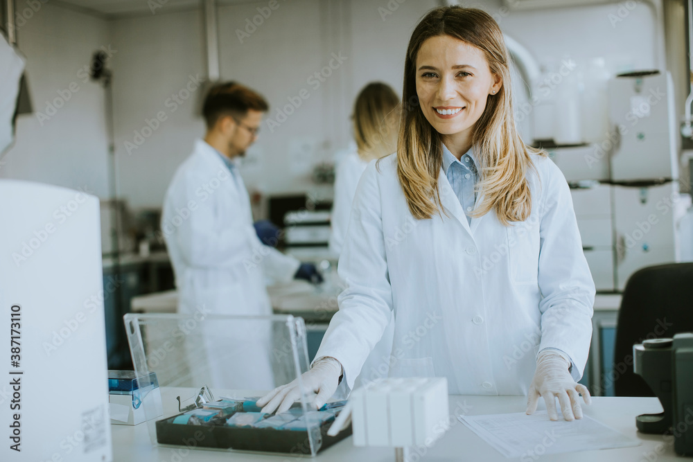 Obraz premium Female scientist in white lab coat standing in the biomedical lab