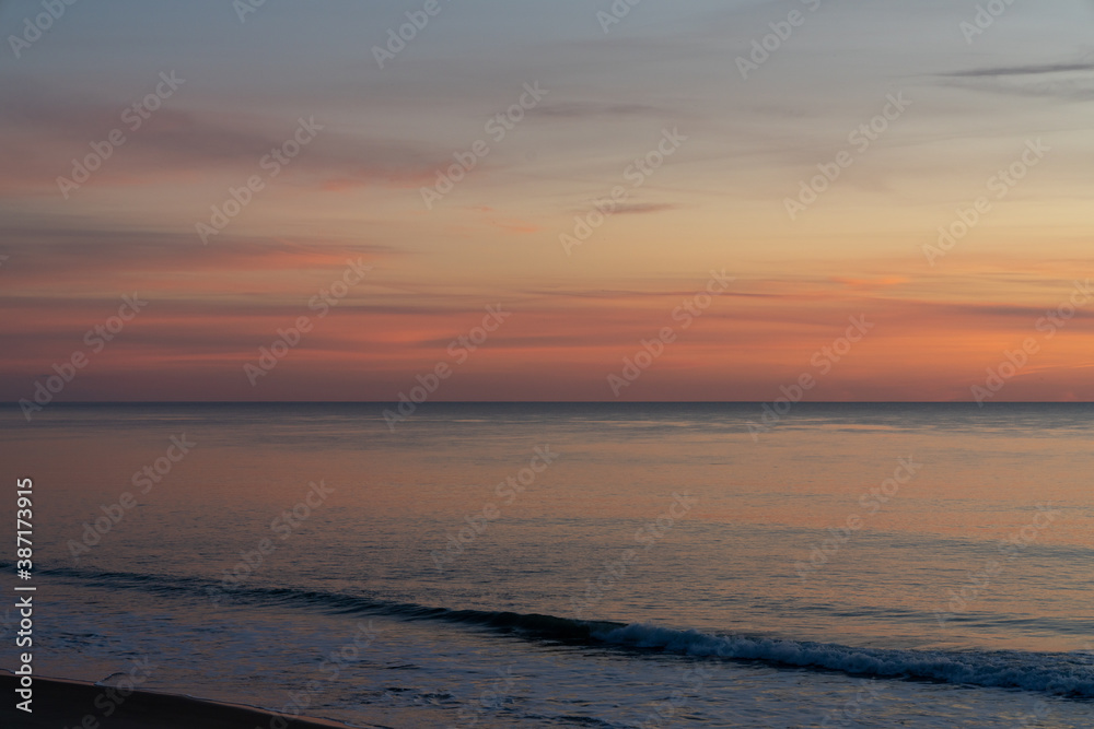beautiful sunset over the ocean with colorful sky and small waves